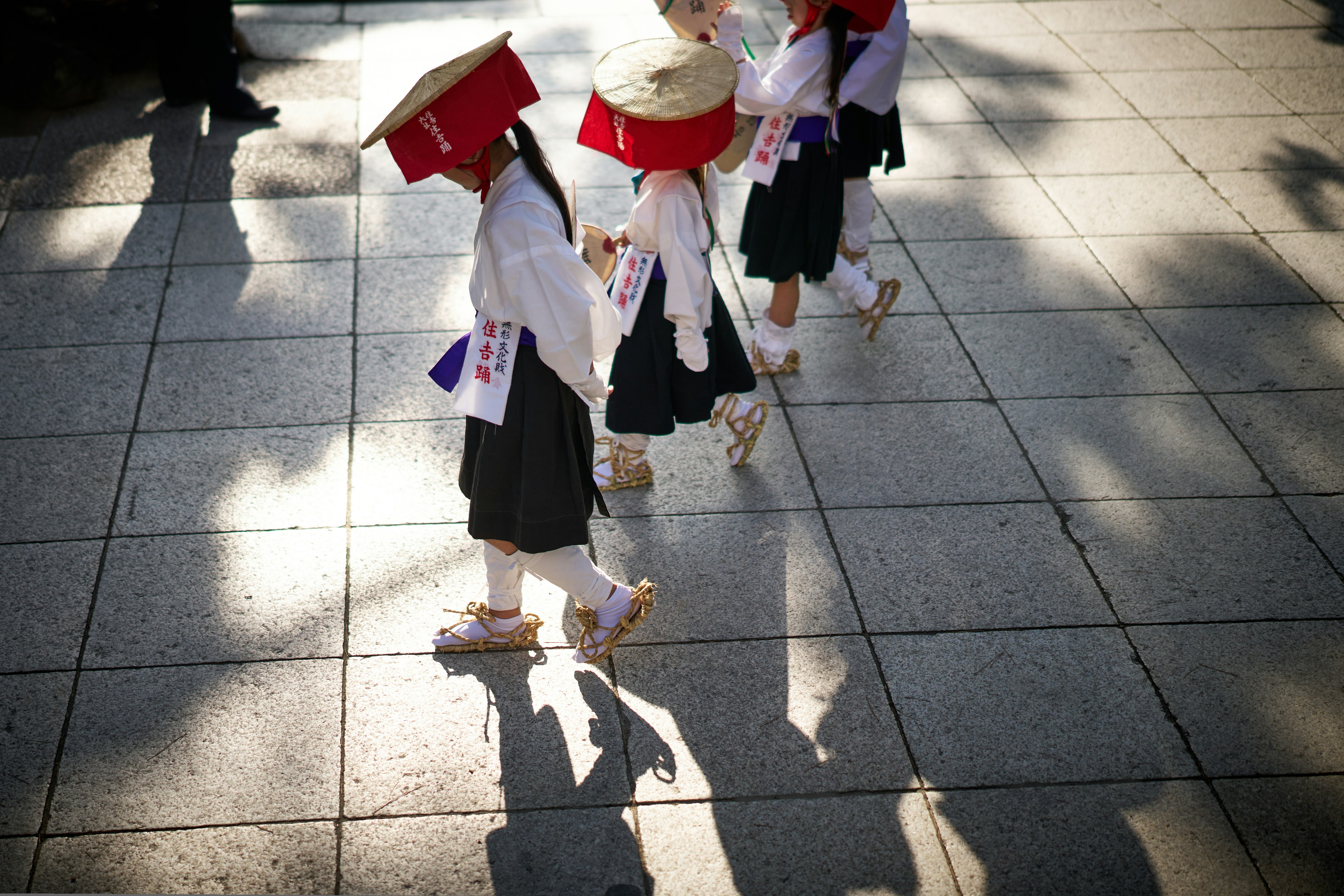 A group of people walking down a sidewalk