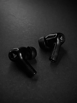 A pair of black earphones sitting on top of a table