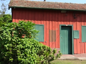 A red building with a green door and windows