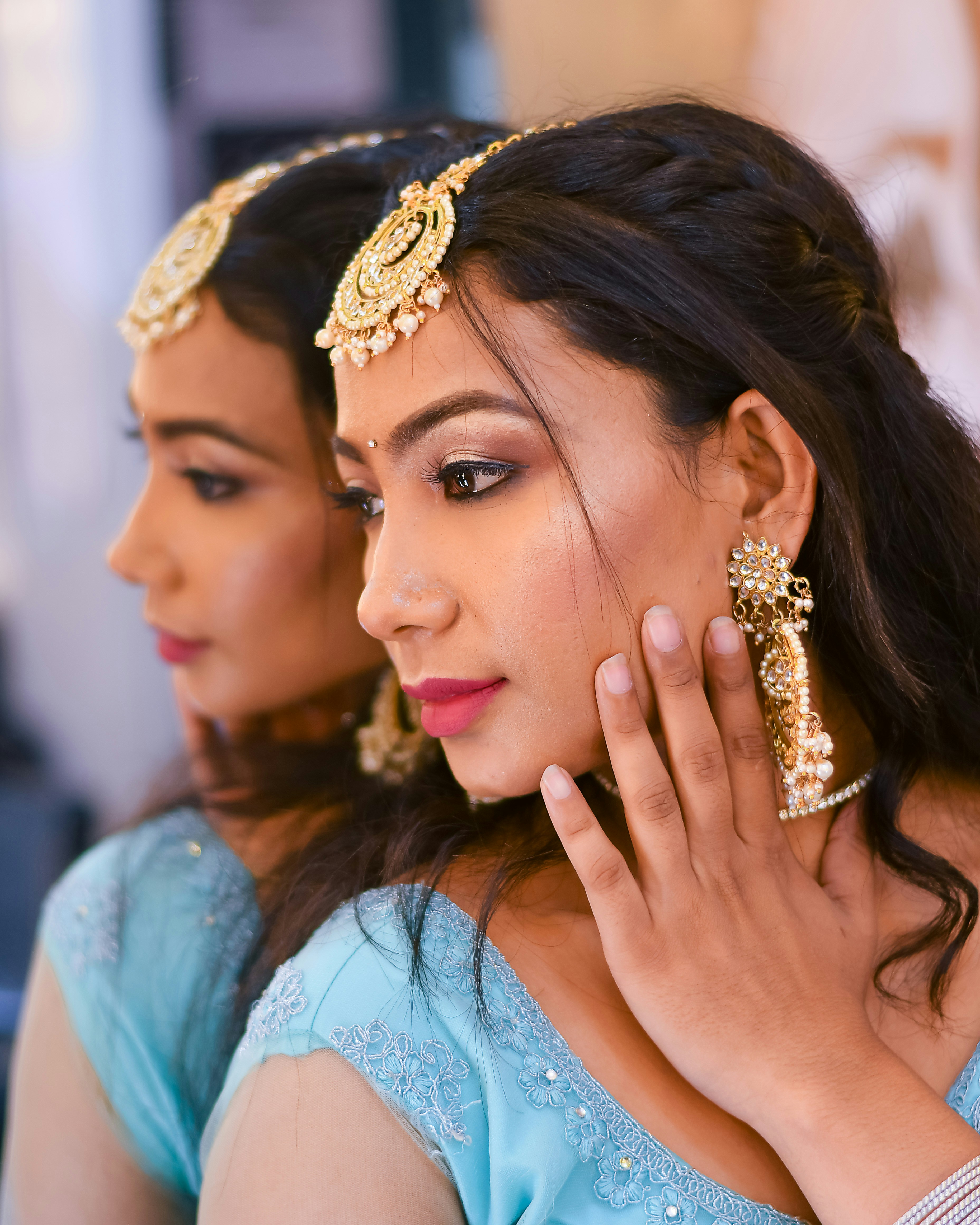 Two women in blue dresses are looking at something