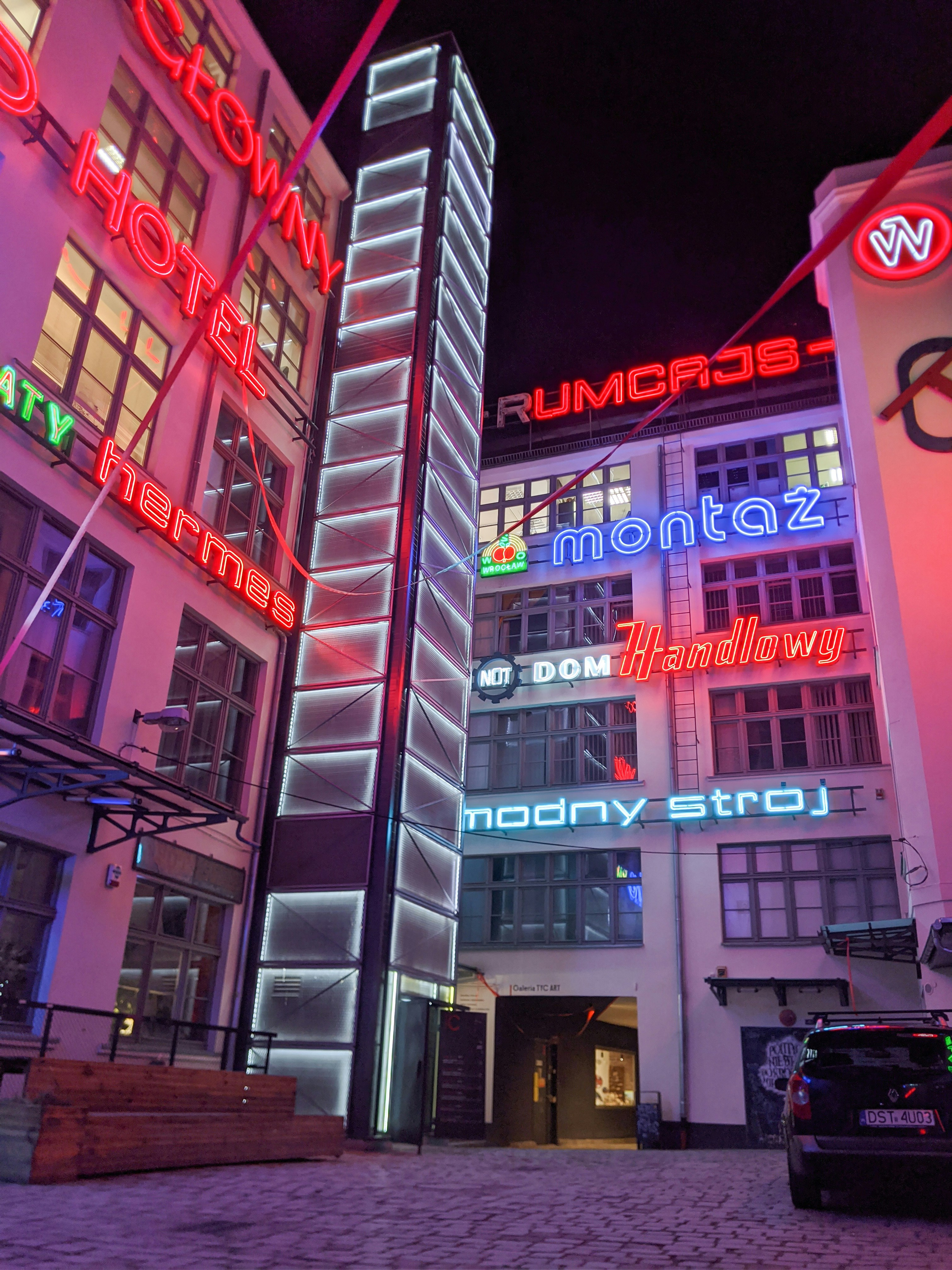 A tall building with neon lights on it's sides