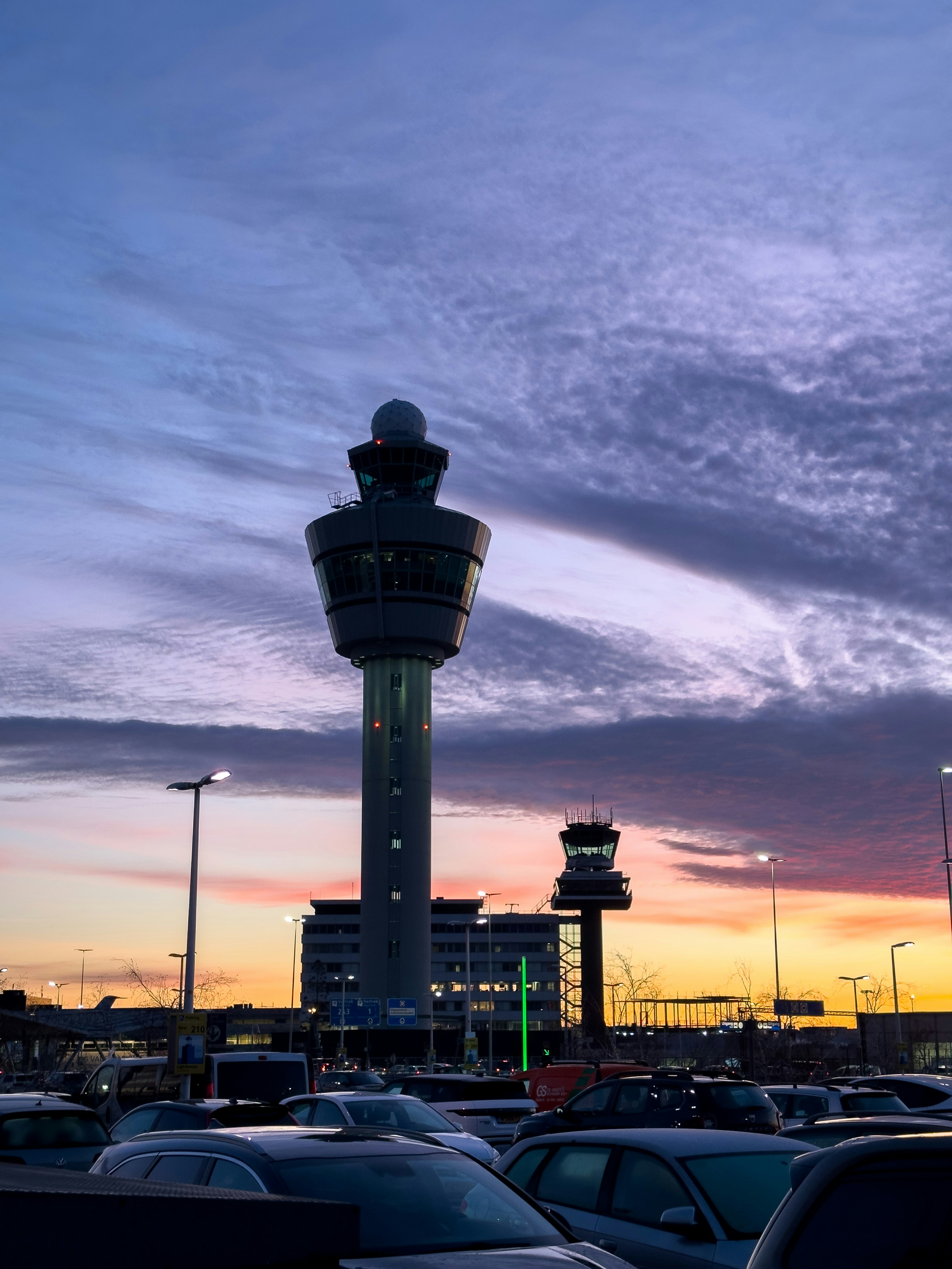 A parking lot filled with lots of cars under a cloudy sky