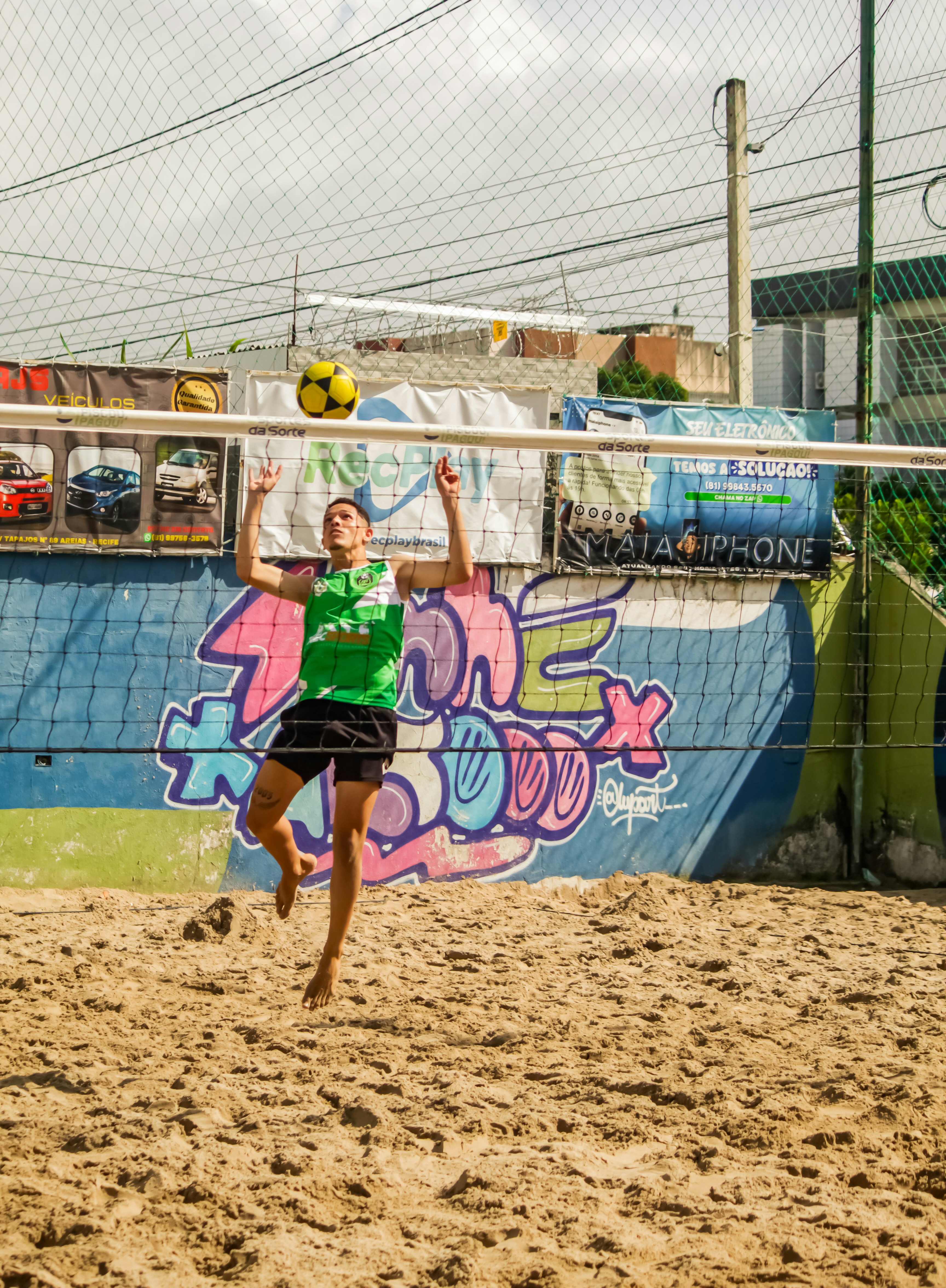 A person jumping up to hit a volley ball