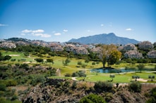 A scenic view of a golf course and mountains