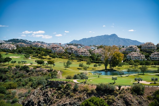 A scenic view of a golf course and mountains
