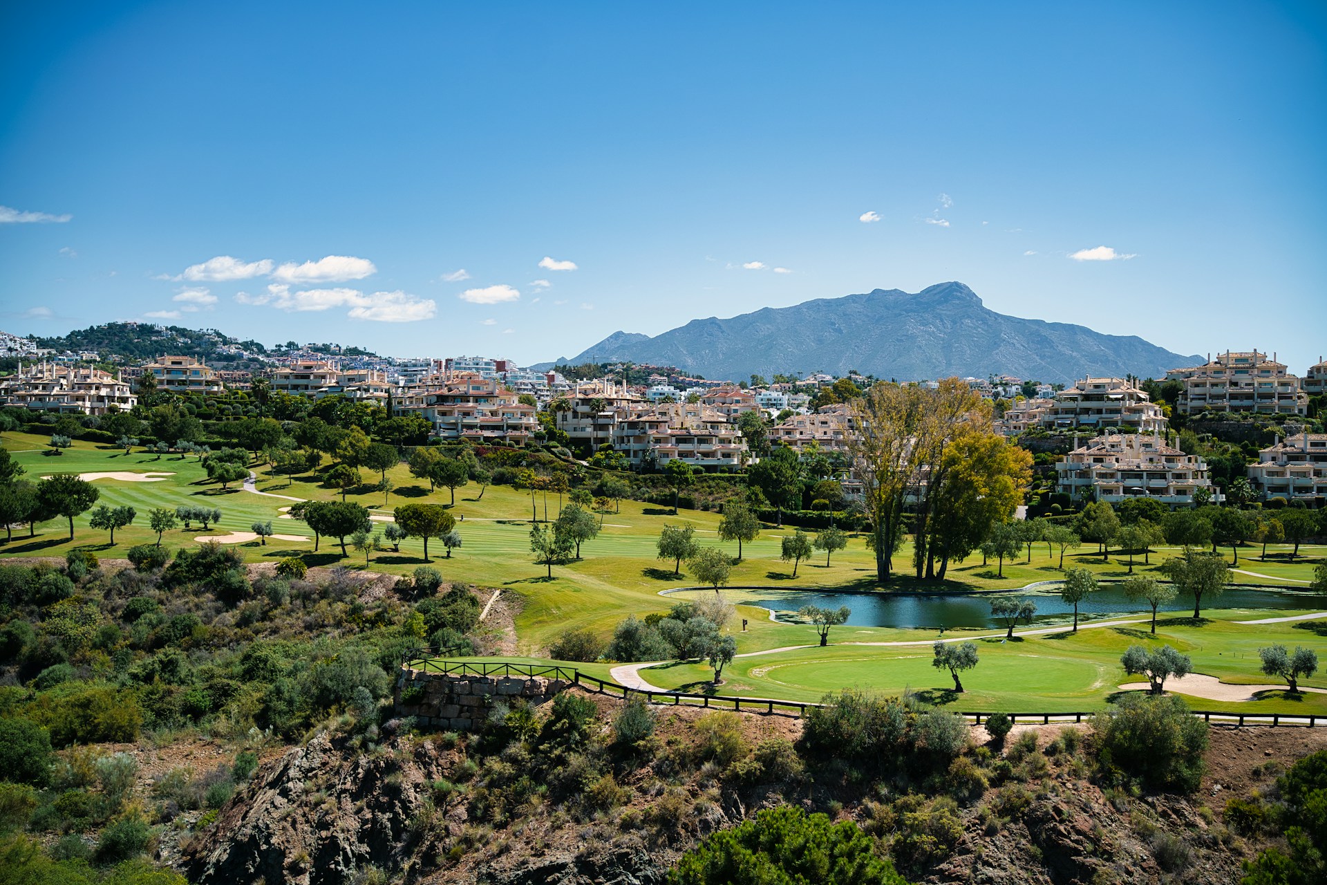 A scenic view of a golf course and mountains