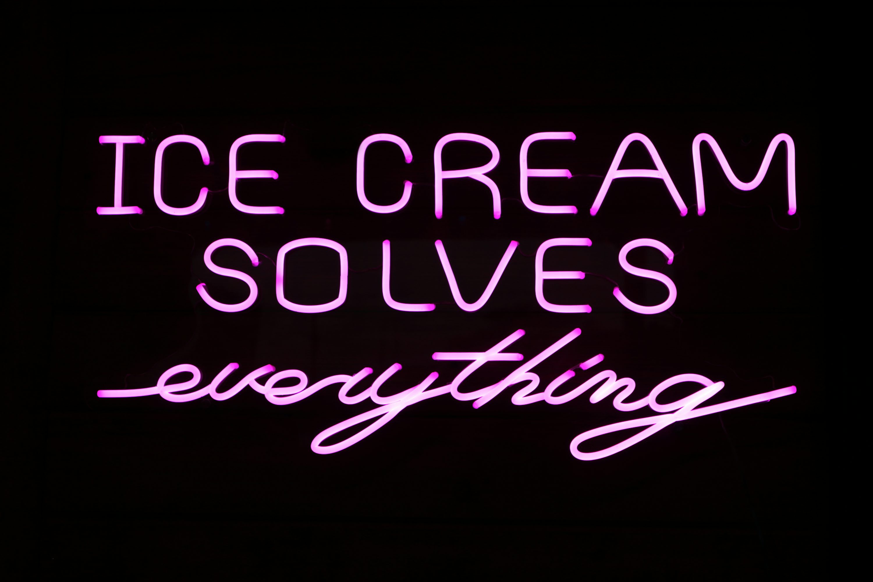 A neon sign that says ice cream solves everything