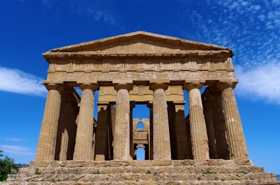 A large stone structure sitting on top of a lush green field