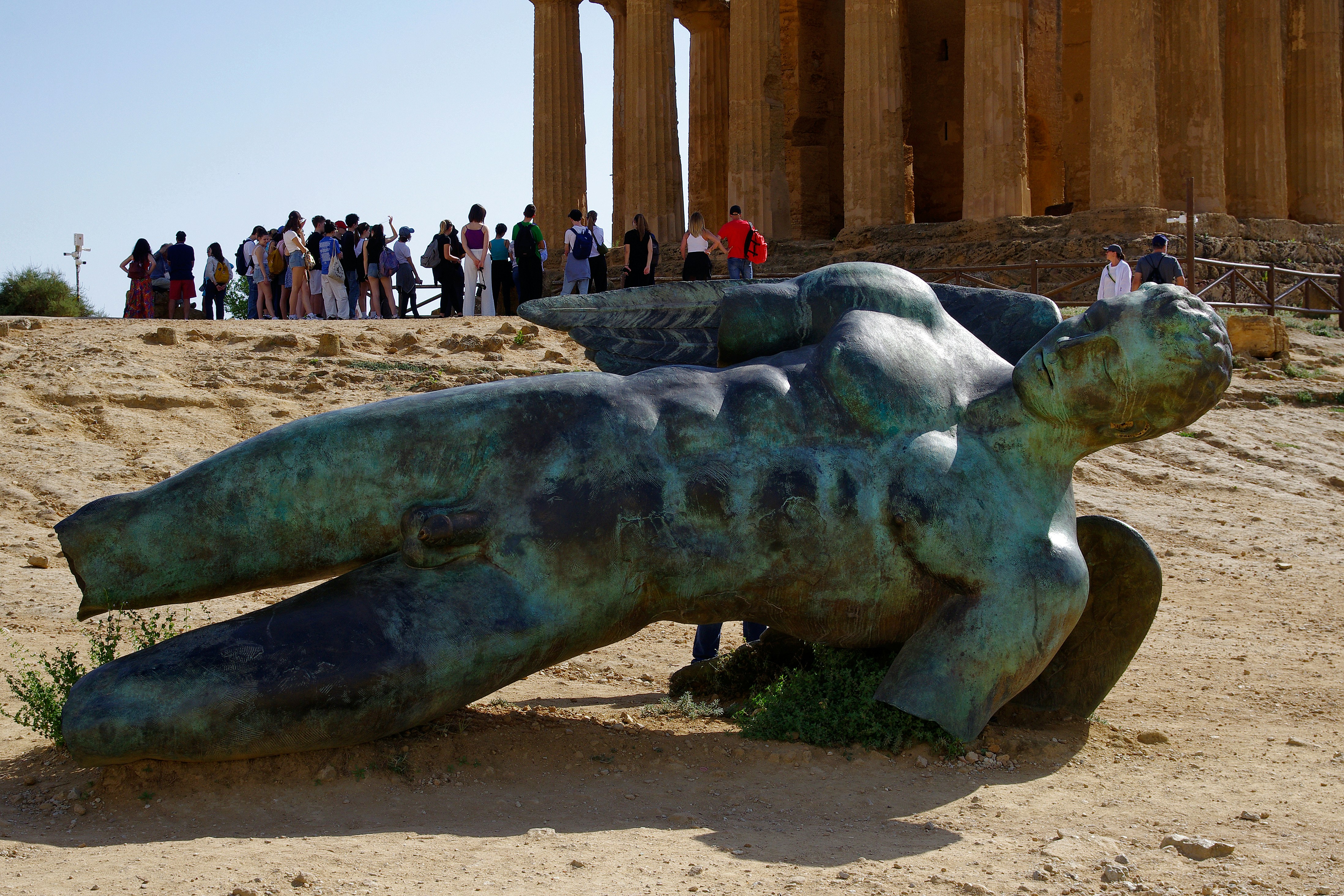 A sculpture of a turtle on the ground in front of a building