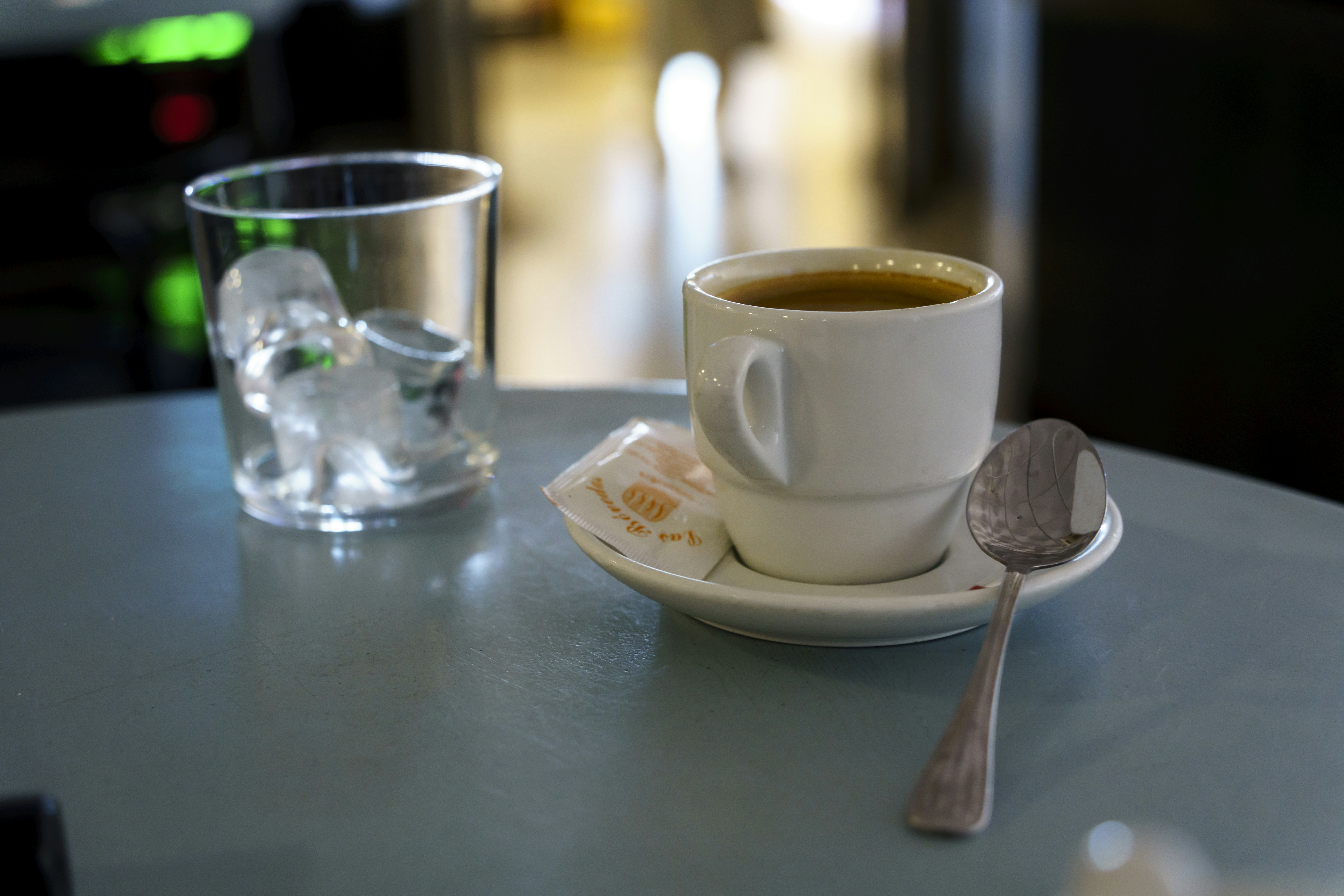 A cup of coffee and a spoon on a table