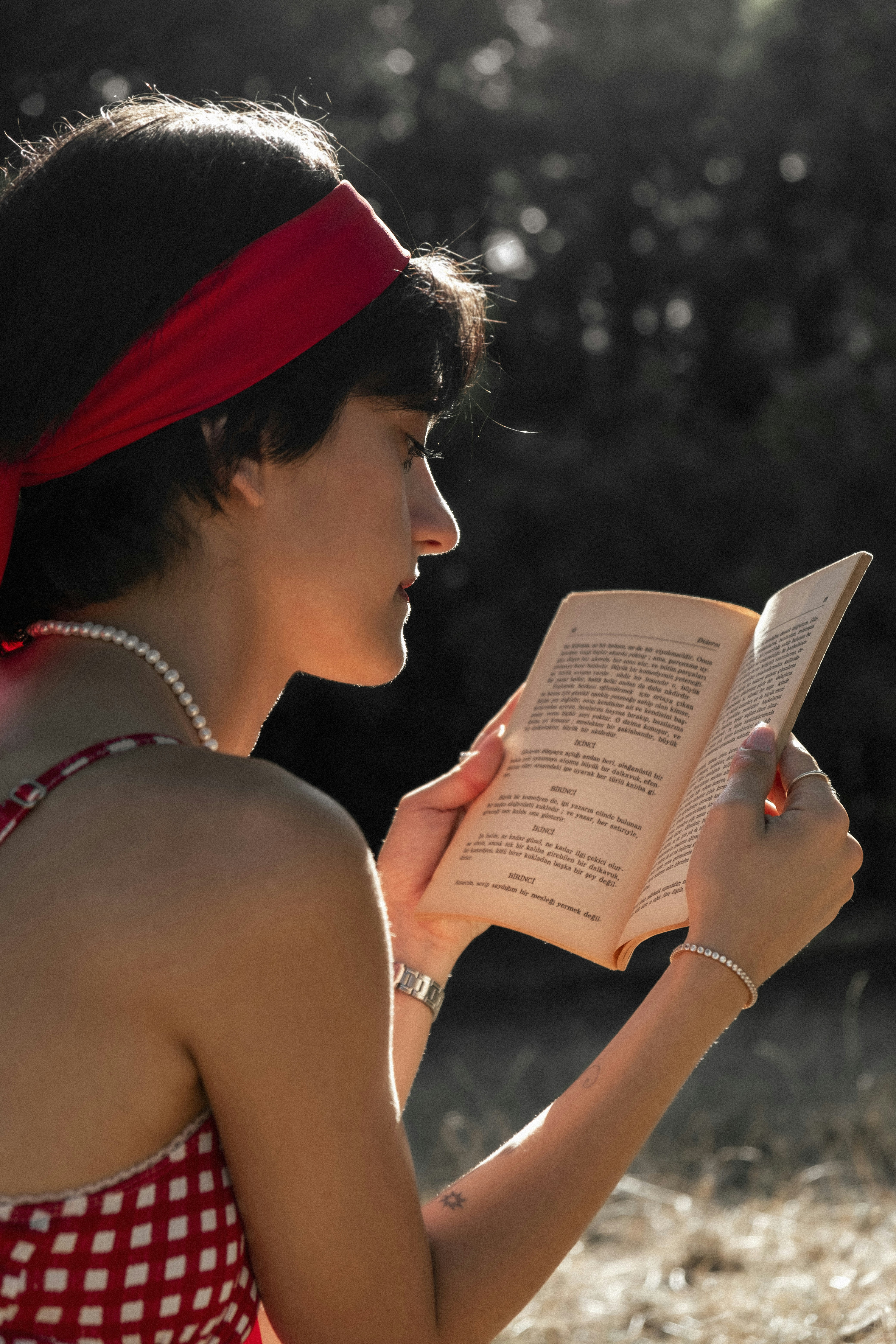 A woman in a red and white dress reading a book