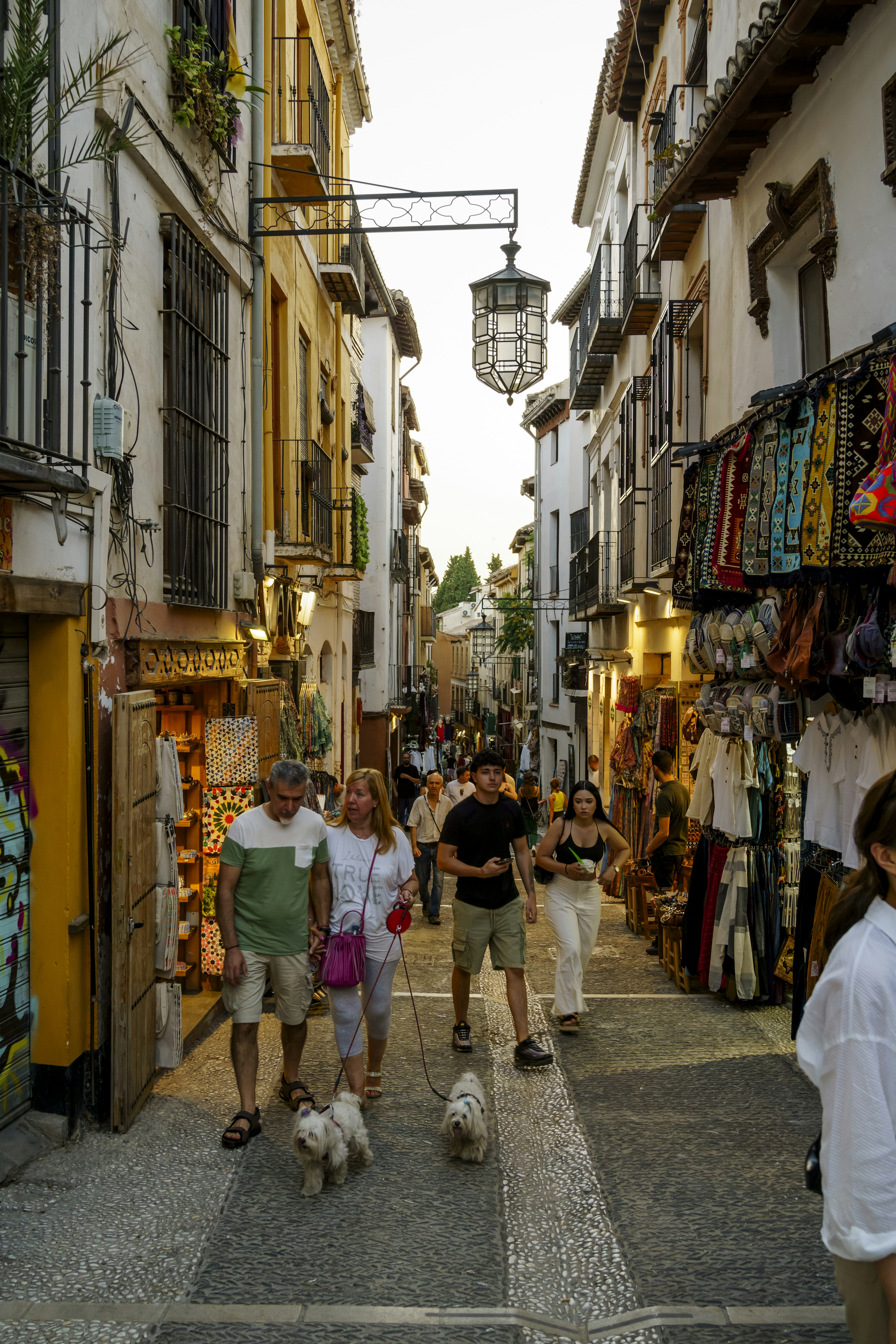 A group of people walking down a narrow street