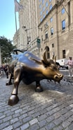 A statue of a bull on a brick sidewalk
