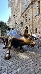 A statue of a bull on a brick sidewalk