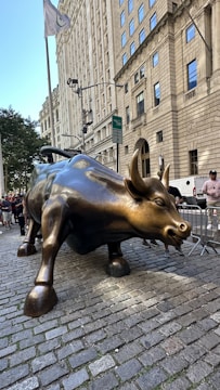 A statue of a bull on a brick sidewalk