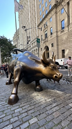 A statue of a bull on a brick sidewalk