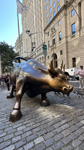 A statue of a bull on a brick sidewalk