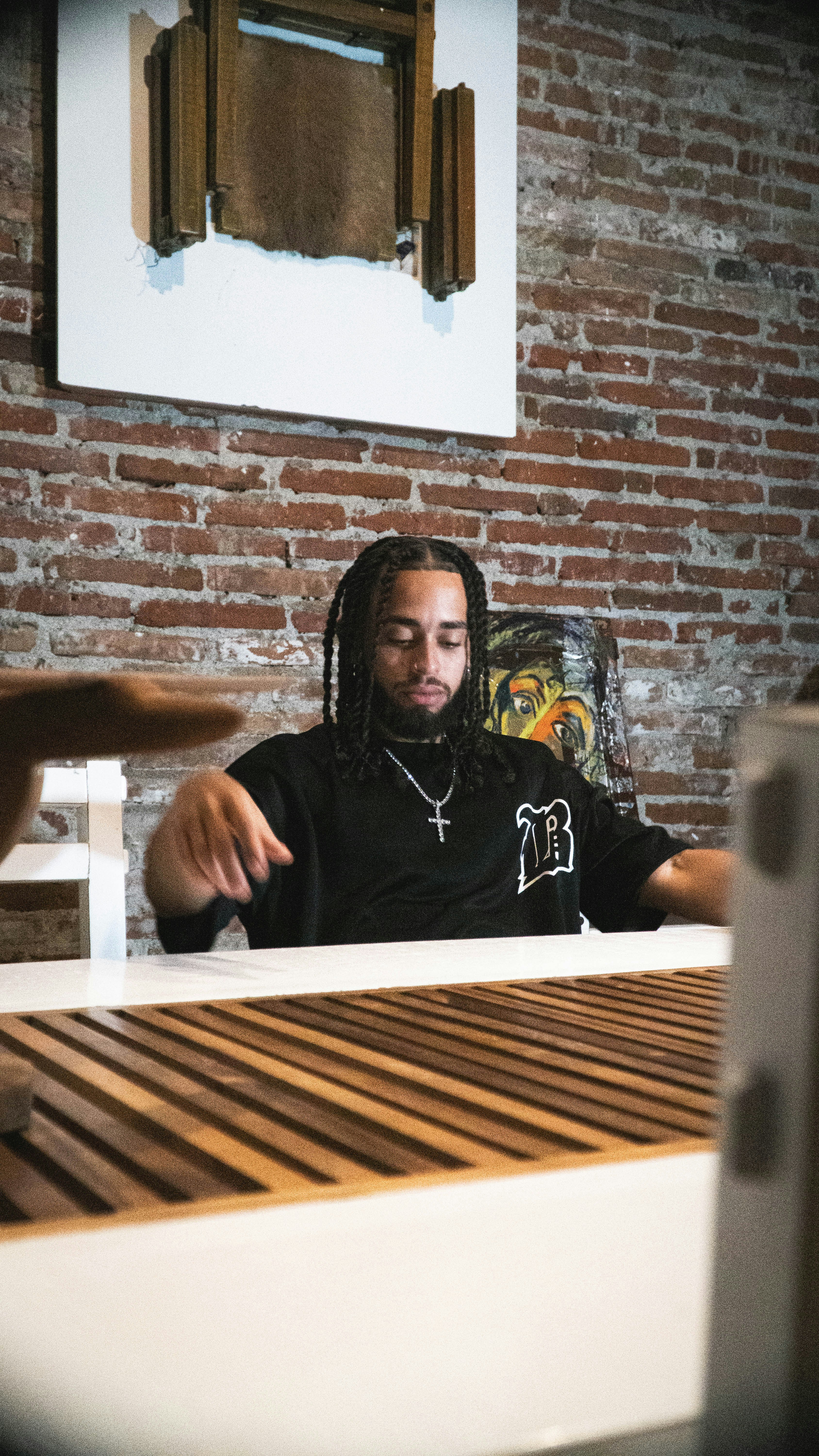 A man with dreadlocks sitting at a table