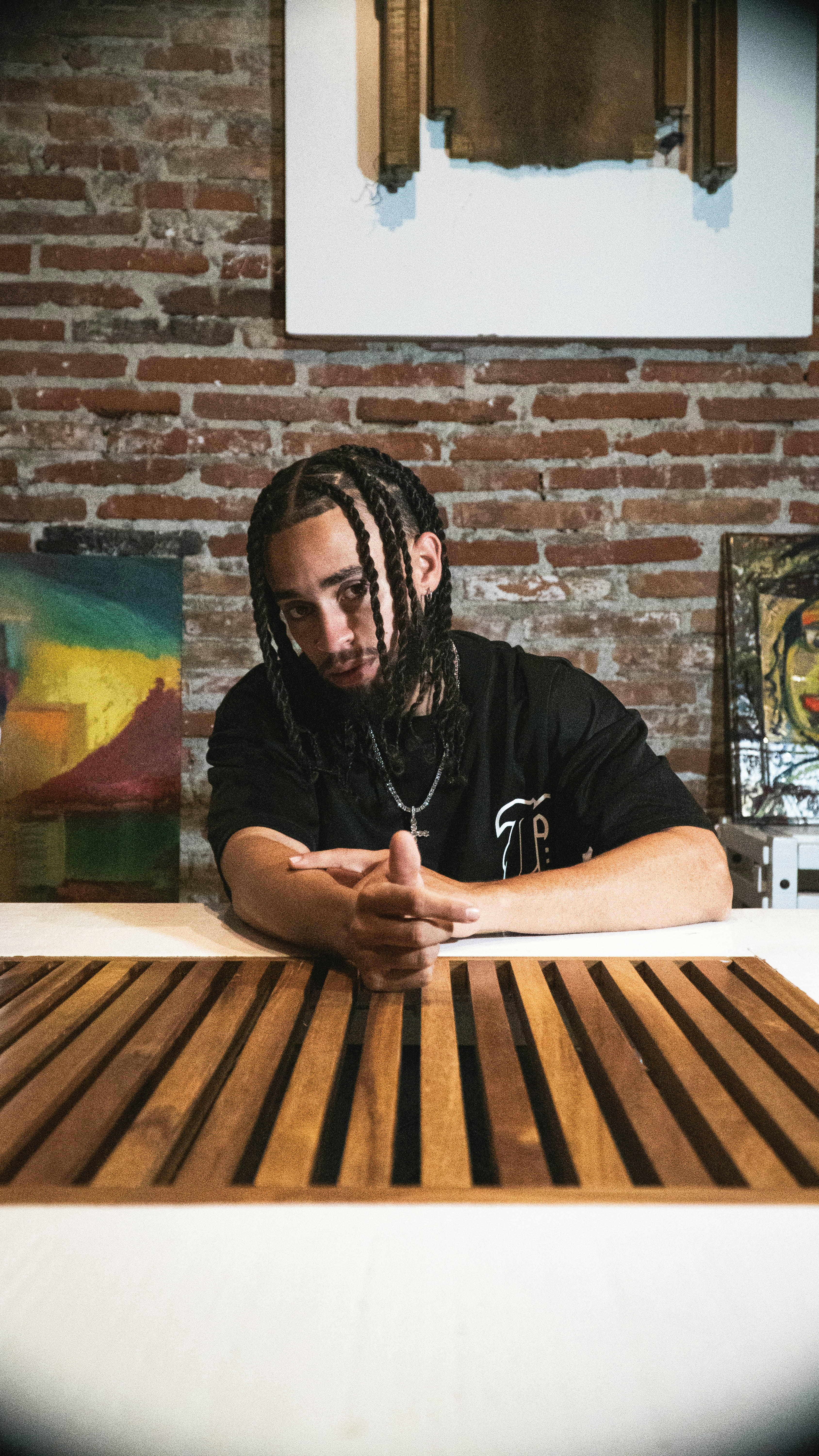 A man with dreadlocks sitting at a table