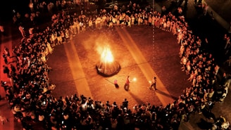 A crowd of people standing around a fire pit
