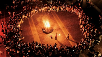 A crowd of people standing around a fire pit
