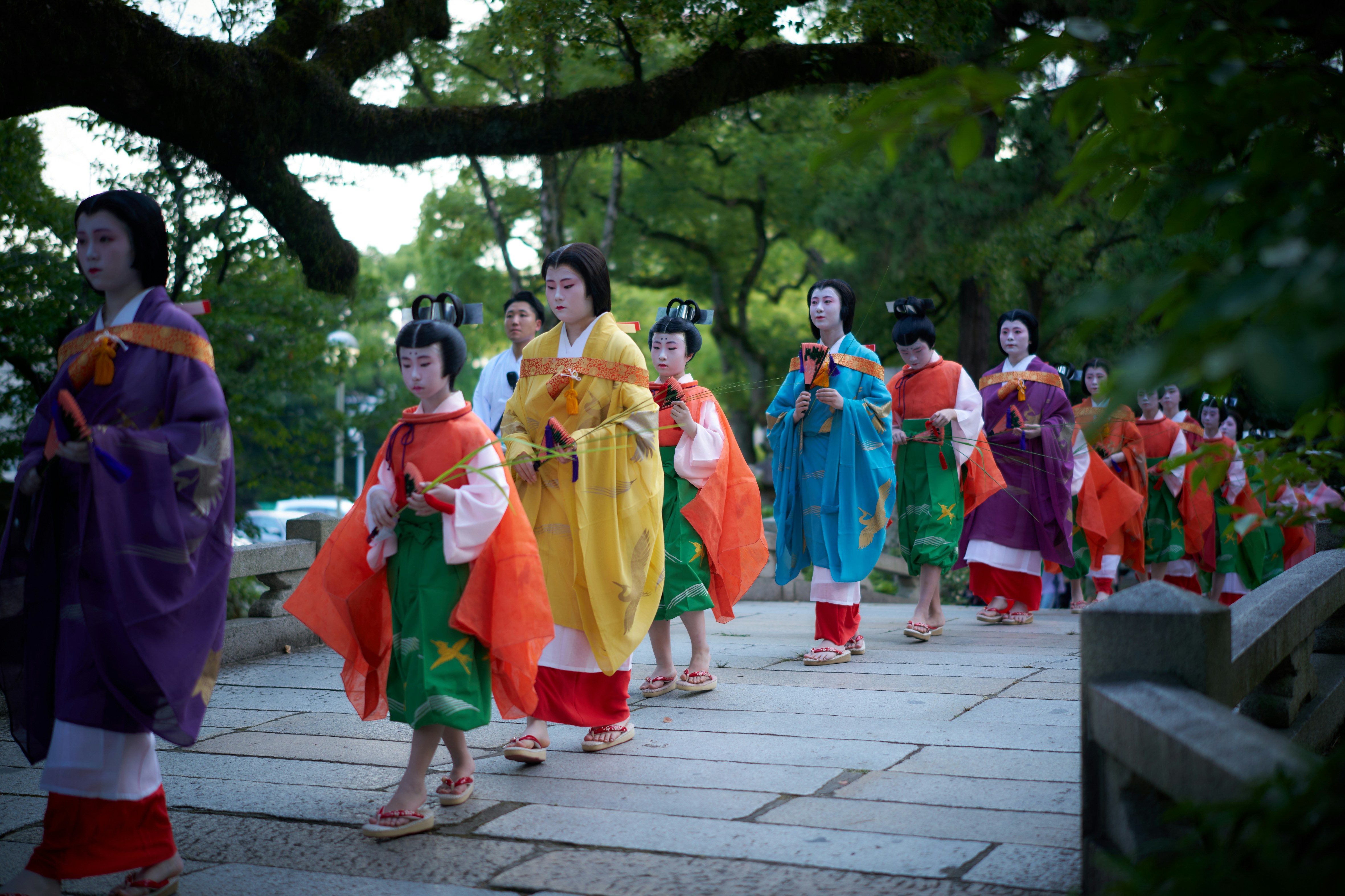 A group of people walking down a sidewalk