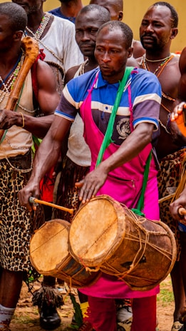 A group of men standing next to each other holding drums