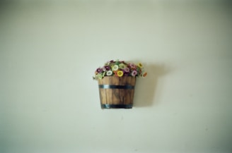 A wooden bucket with flowers hanging on a wall