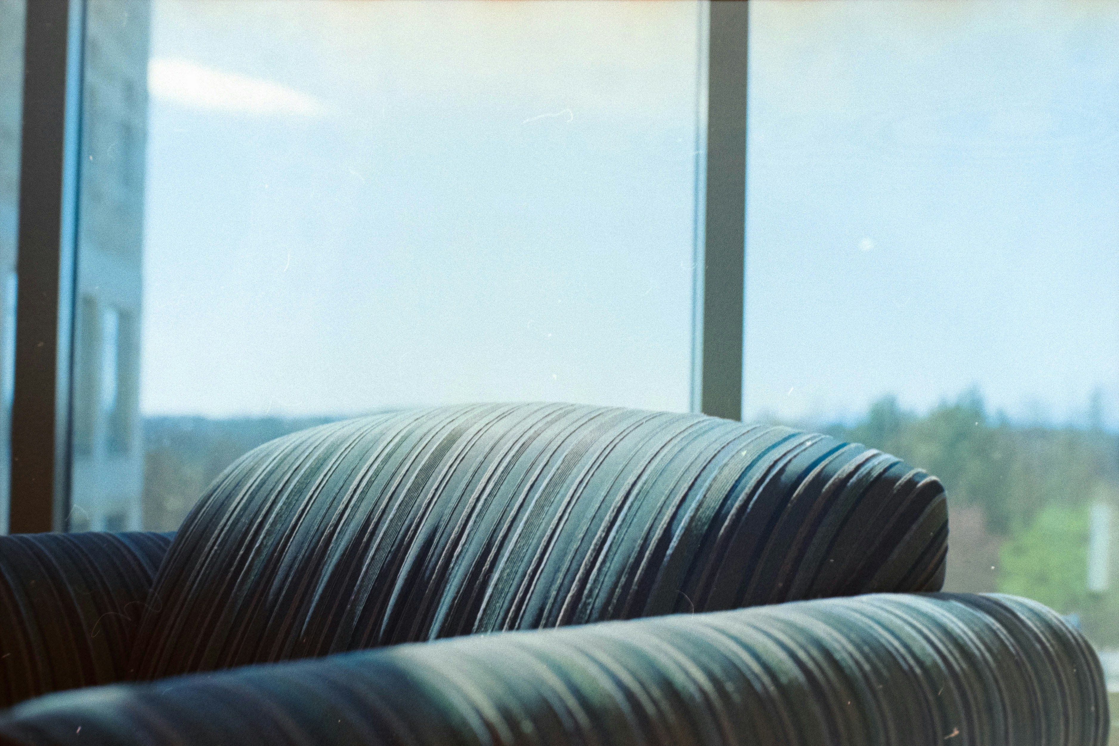 A black couch sitting in front of a window