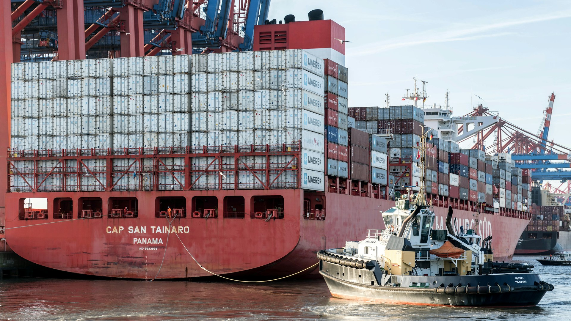 A large red and white container ship in the water