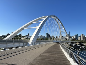 A bridge over a body of water with a city in the background