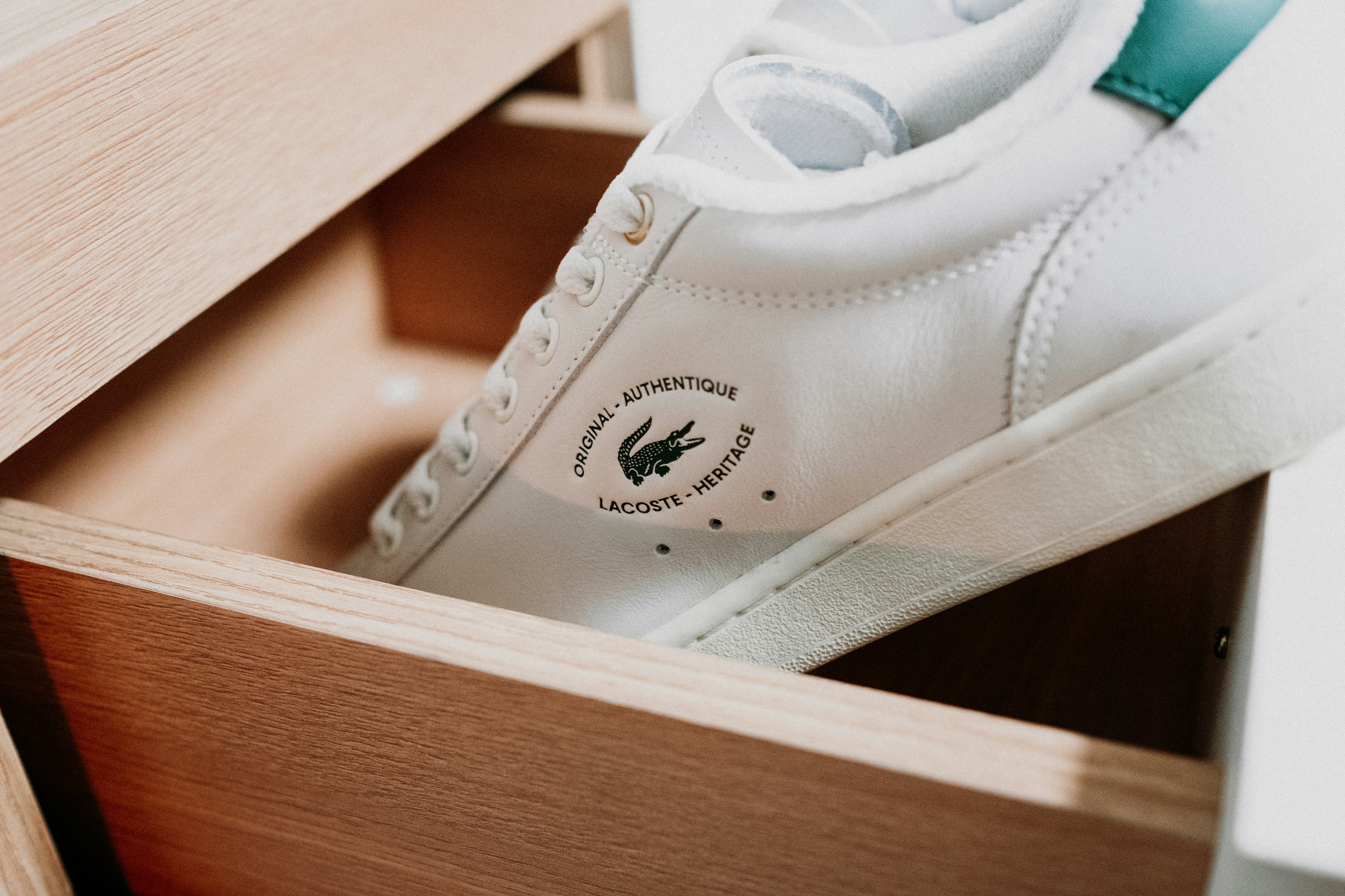 Une paire de baskets blanches à l’intérieur d’une boîte en bois