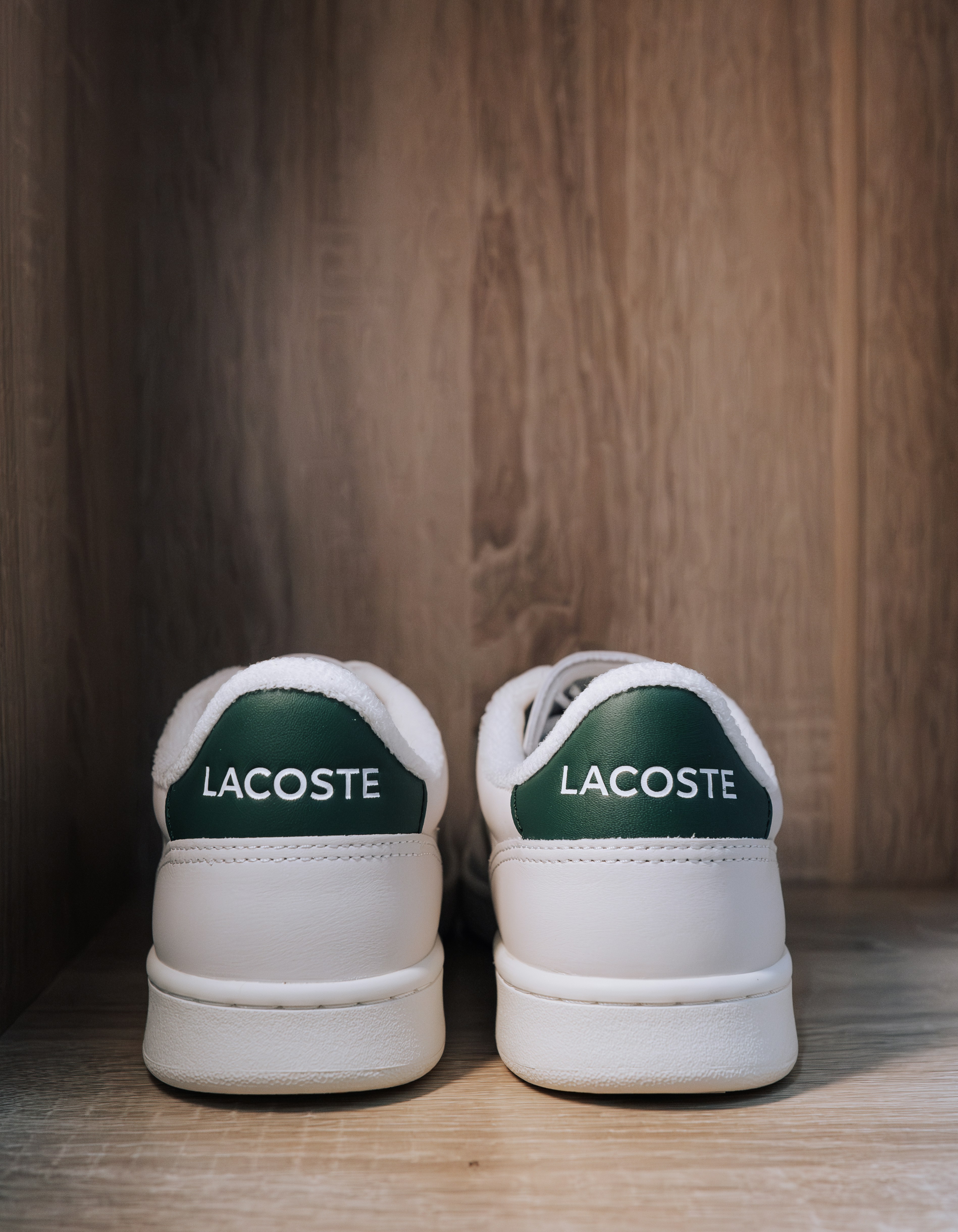 Une paire de chaussures lacoste posée sur une étagère