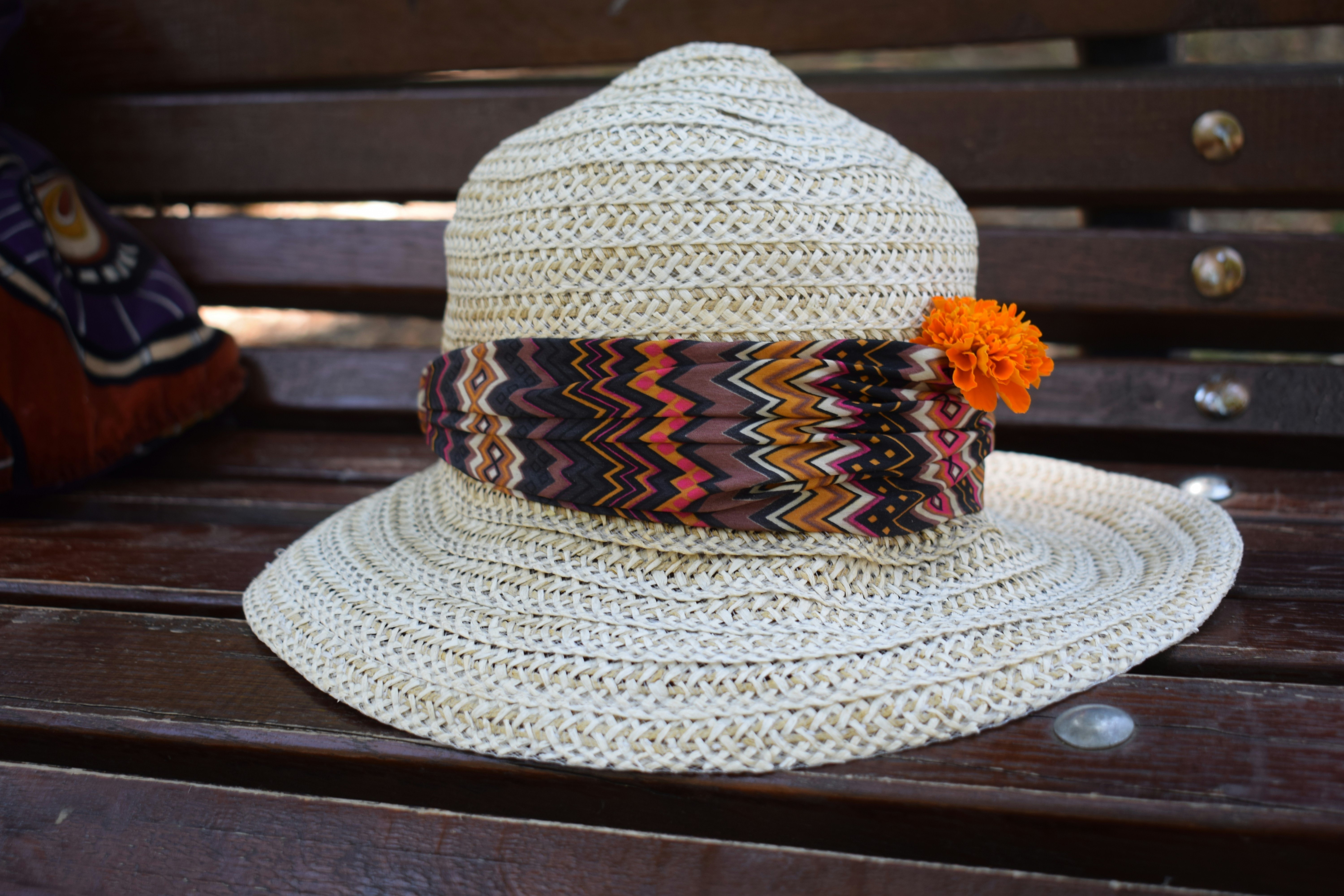 A white hat sitting on top of a wooden bench