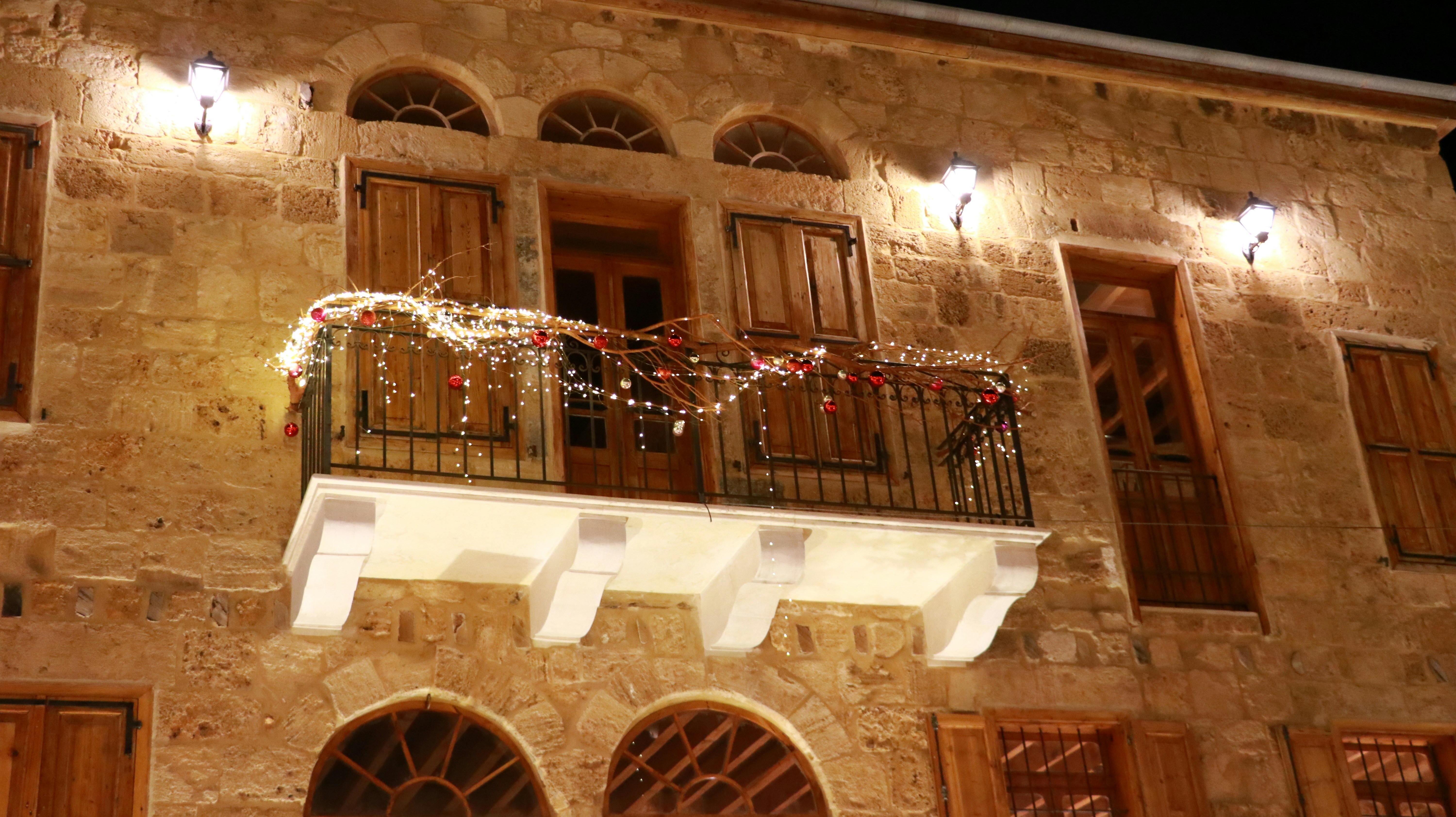 A building that has a balcony and a balcony with lights on it
