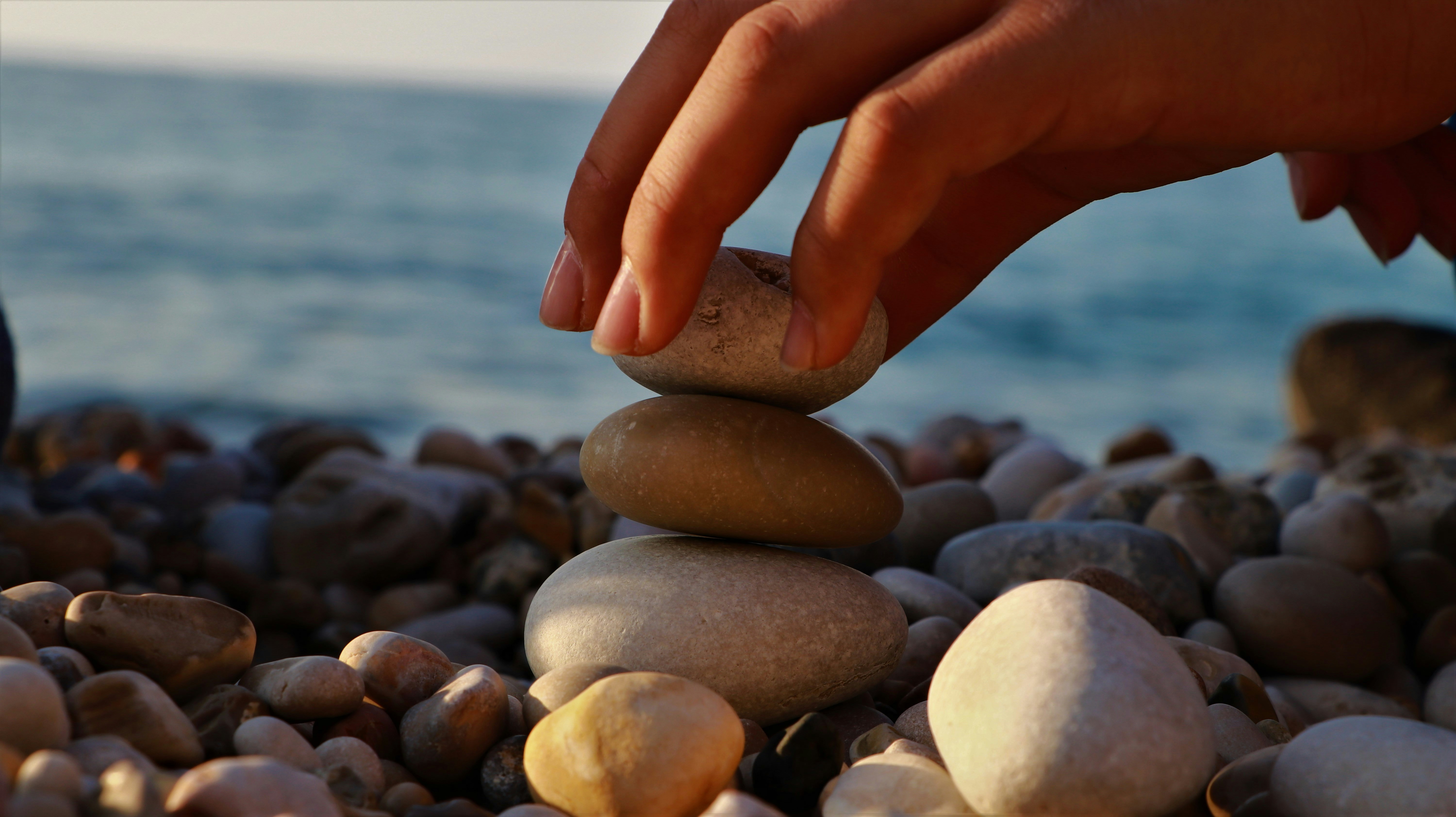 A person stacking rocks on top of each other