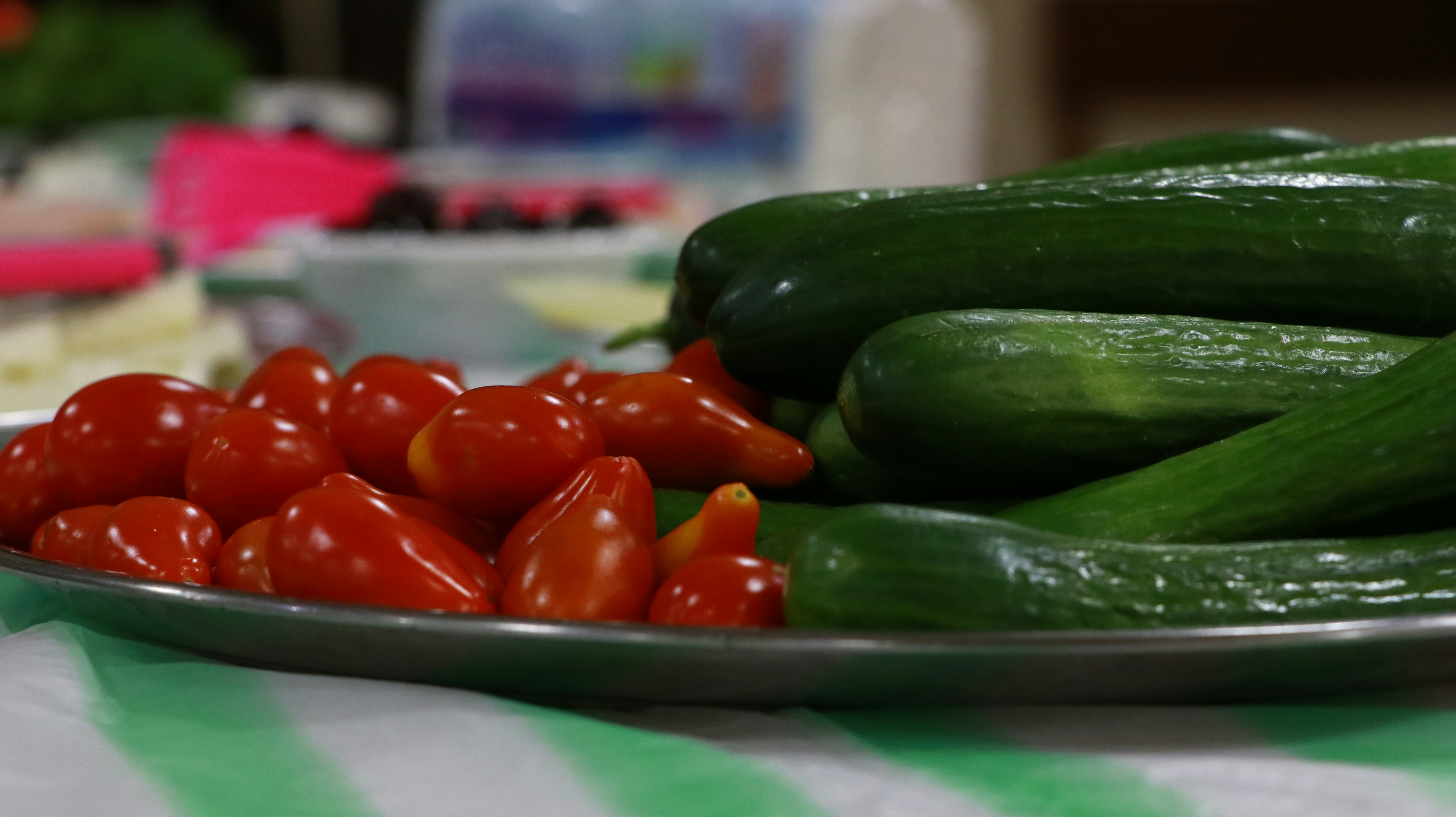 A plate of cucumbers and tomatoes on a table