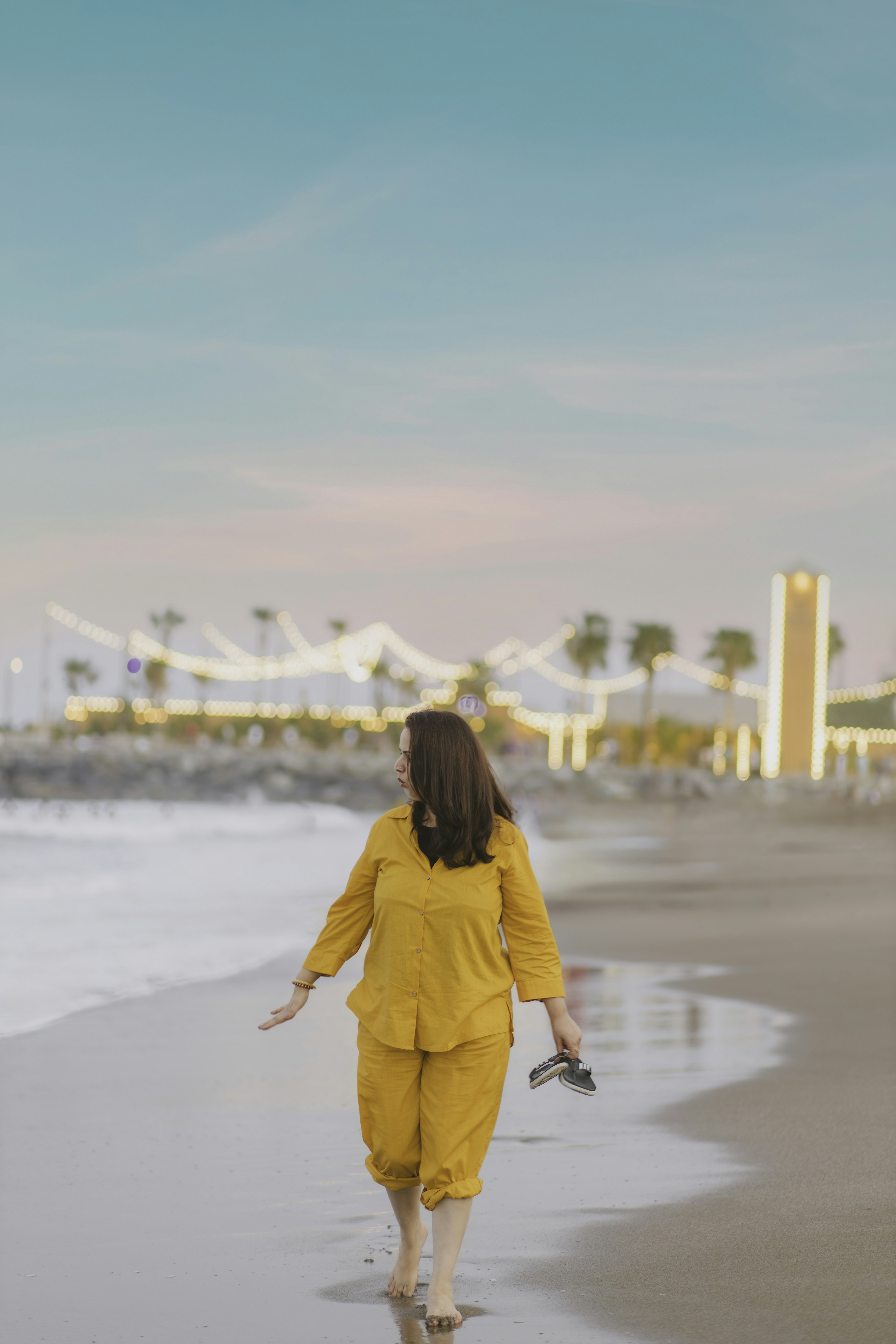 Una mujer caminando por una playa junto al océano