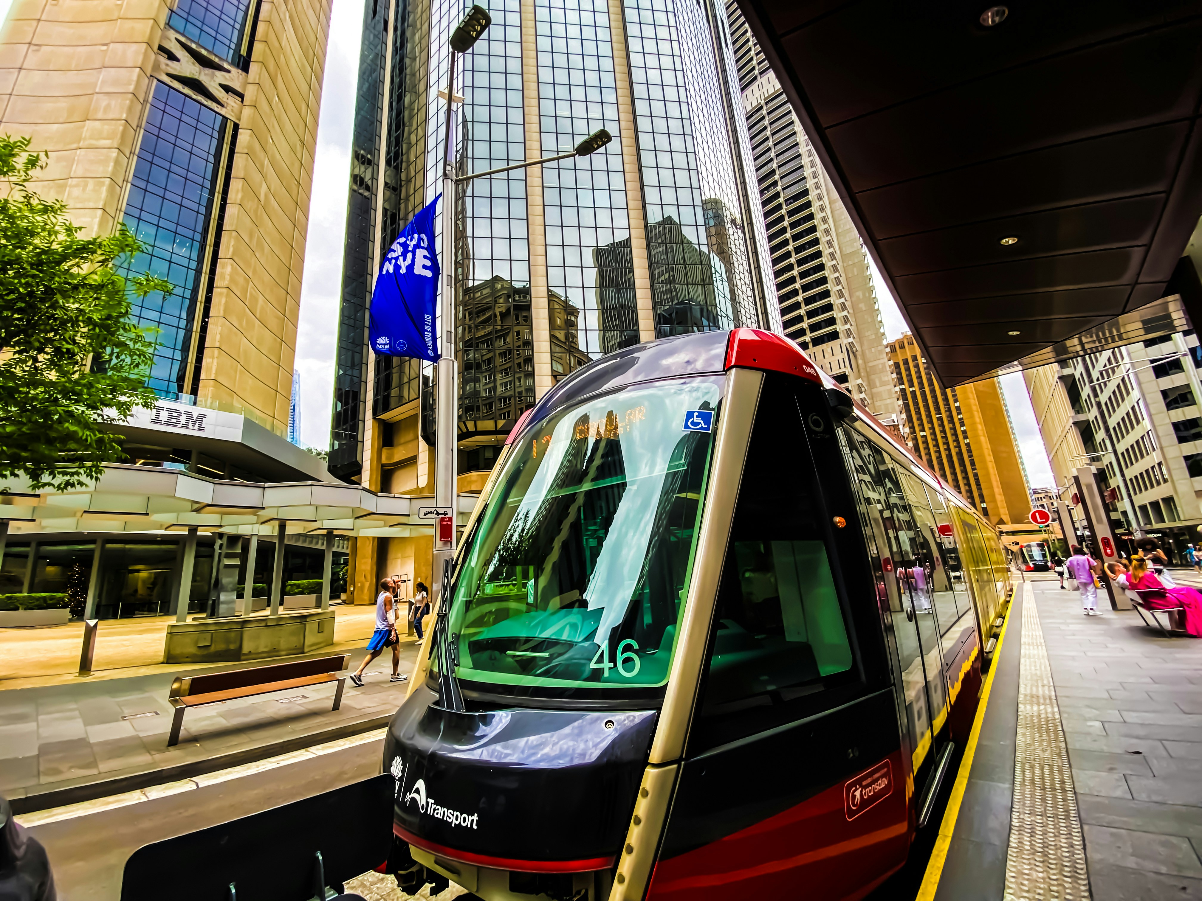 A train traveling down a street next to tall buildings