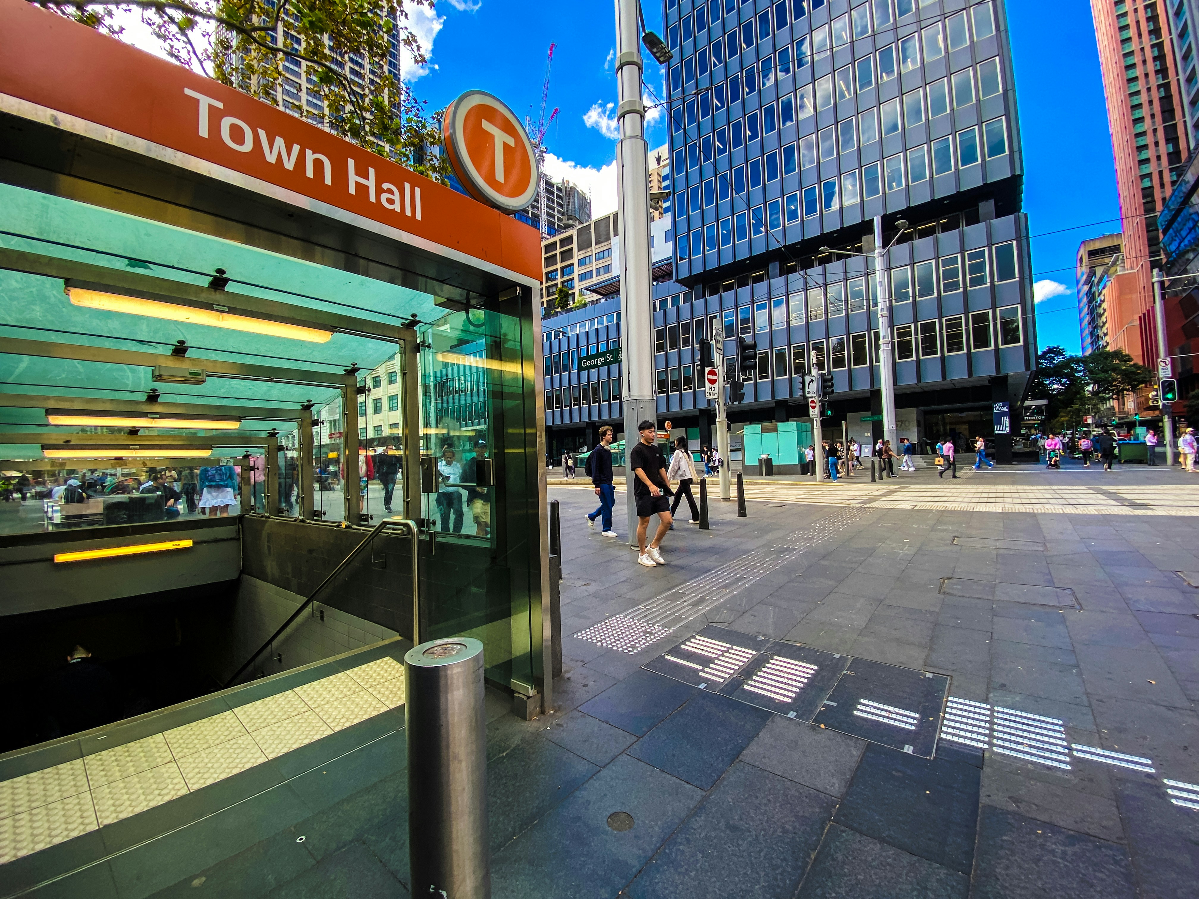 A bus stop in a city with tall buildings in the background