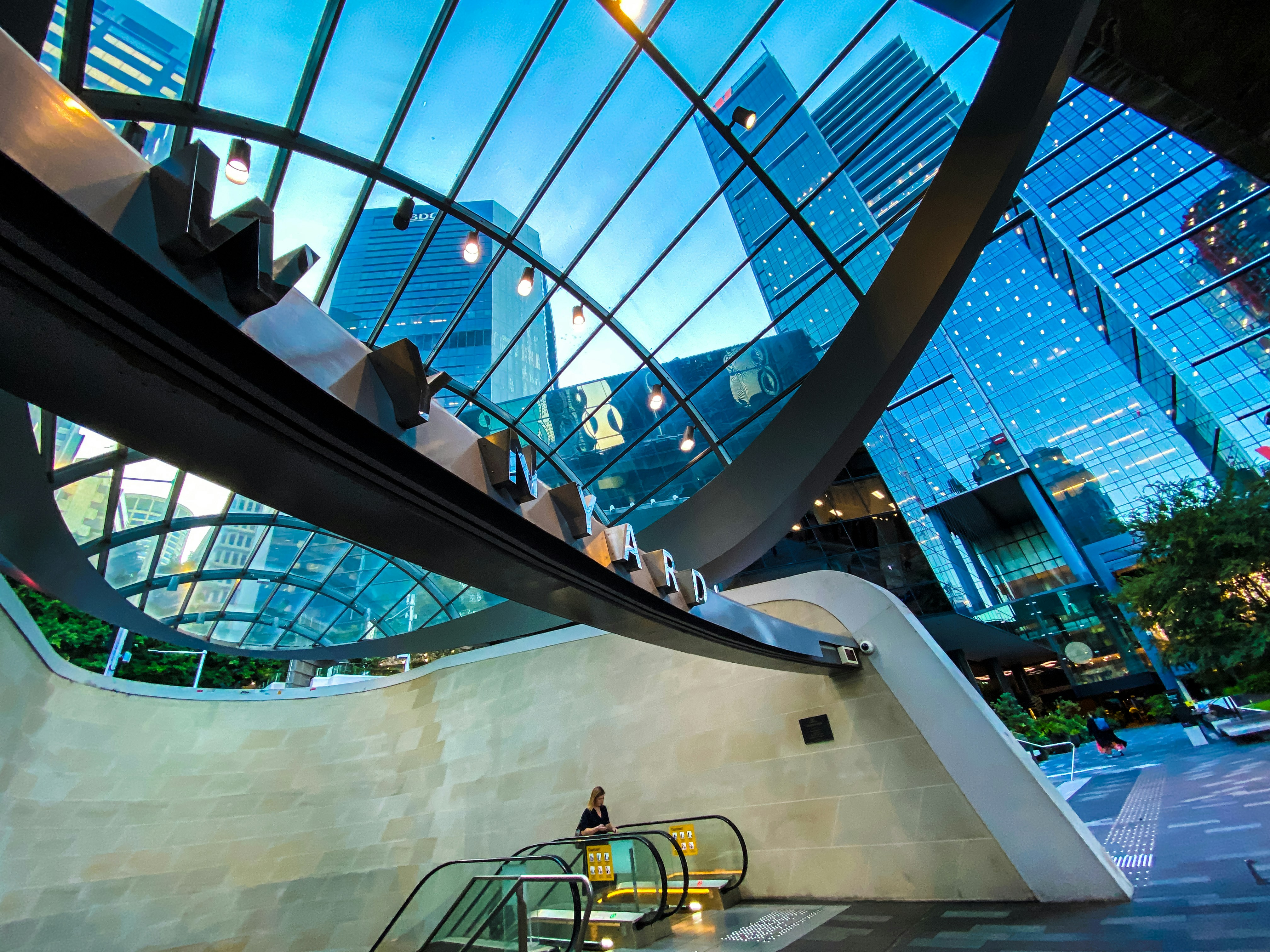 An escalator inside of a building with a skylight, International Student Navigator Australia: Discover the vibrant city of Sydney through stunning visuals on Unsplash! 📸✨ From the iconic Sydney Opera House 🏛️ to the serene Bondi Beach 🏖️, explore breathtaking imagery capturing the essence of this multicultural metropolis 🌏. Perfect for international students seeking a glimpse into their future home, these photos offer a sneak peek into the diverse and dynamic lifestyle Sydney has to offer.