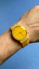 A person wearing a yellow watch on their wrist
