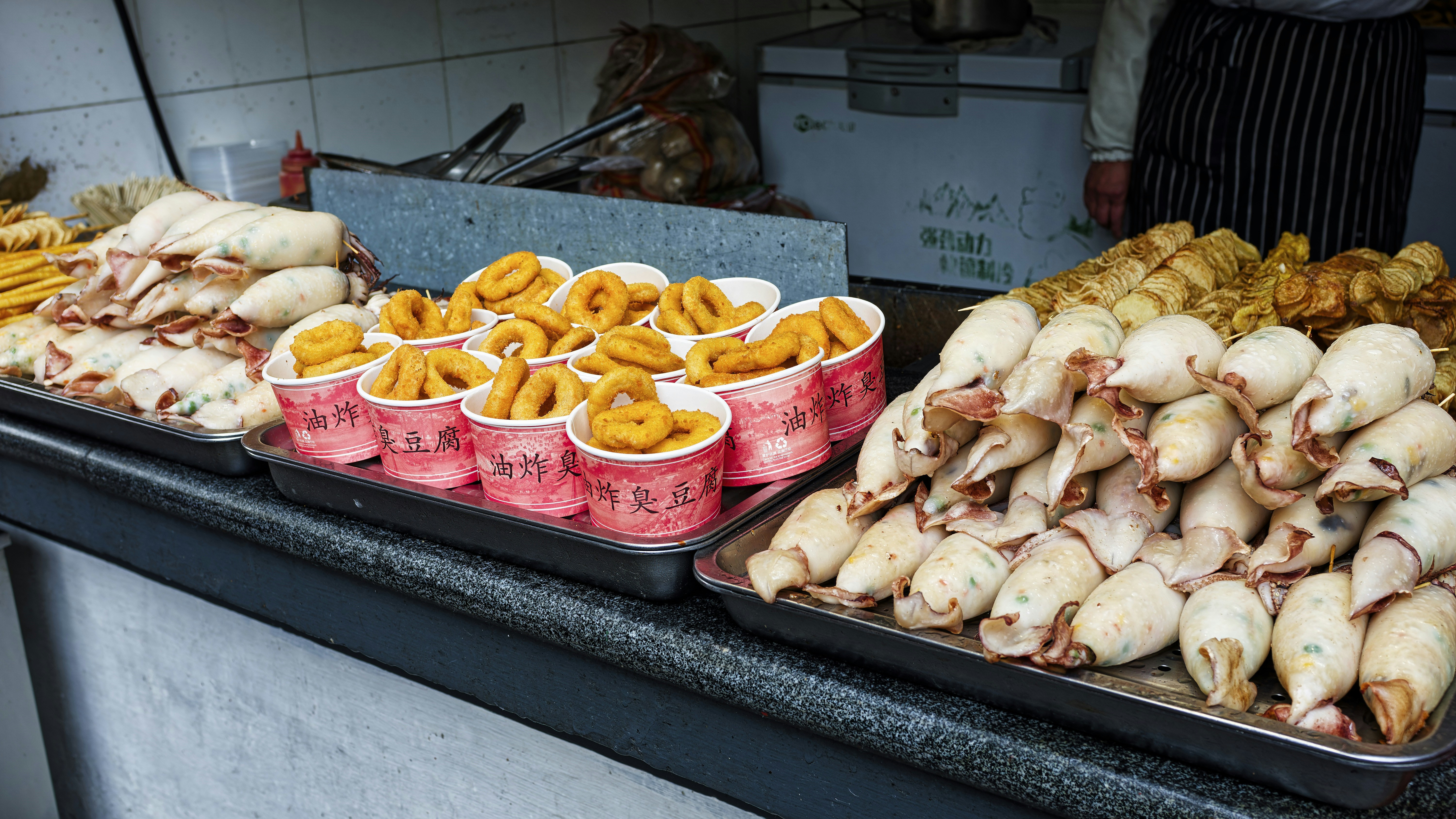 Several trays of food sitting on a counter