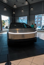 A silver car is on display in a showroom