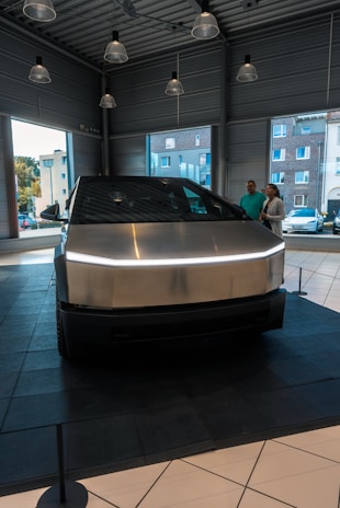 A silver car is on display in a showroom