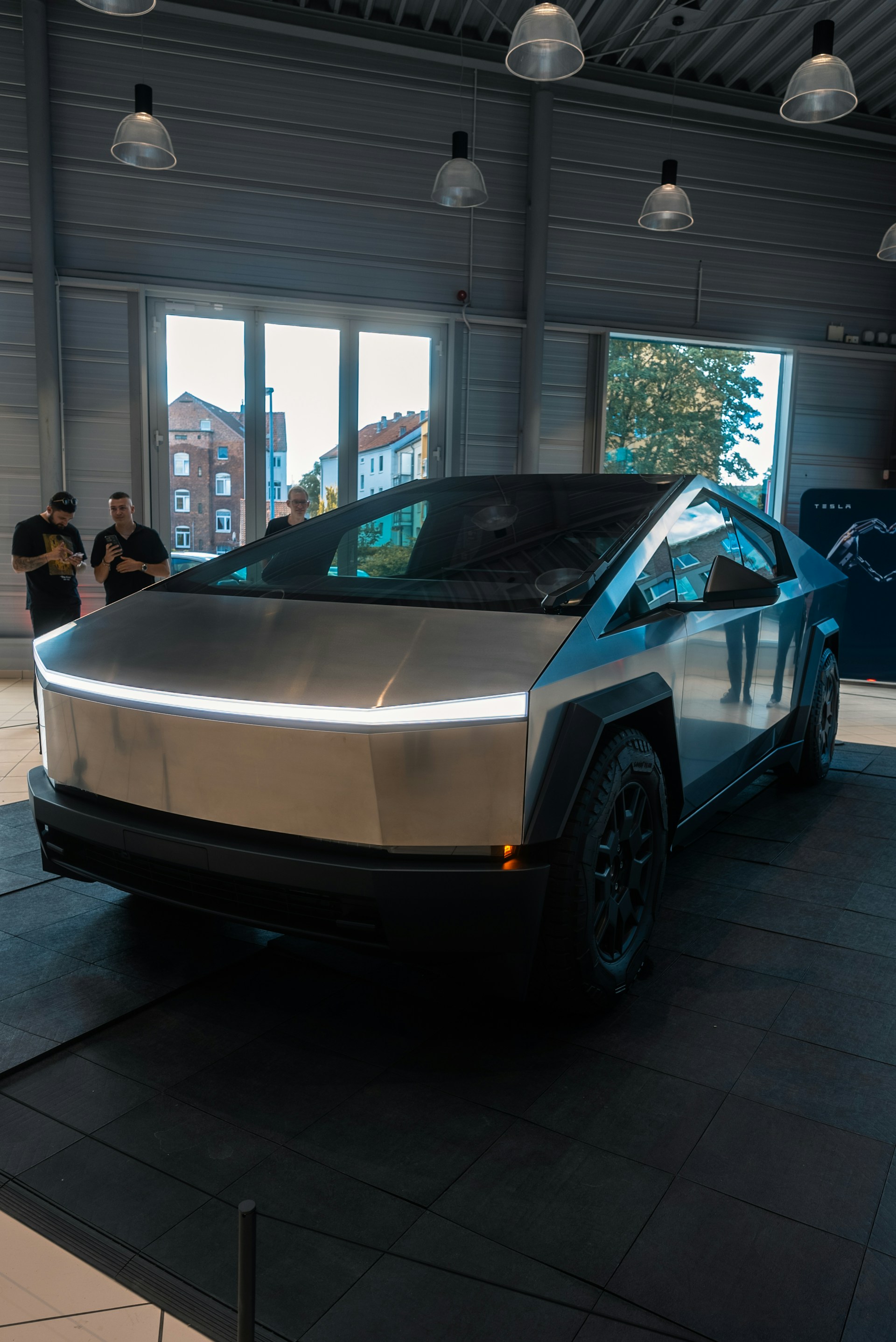 A silver car is on display in a building