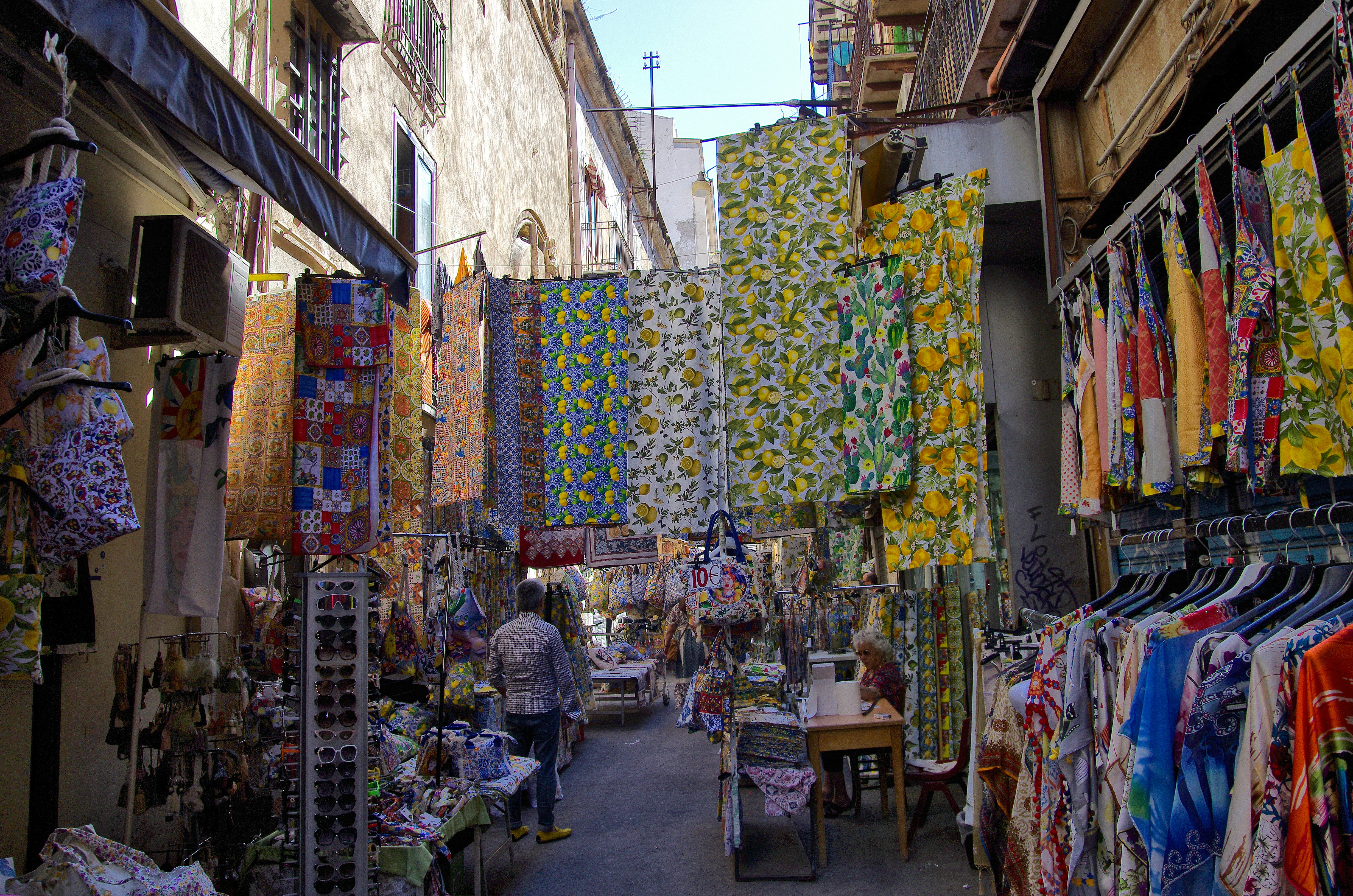 A man walking down a street next to a store