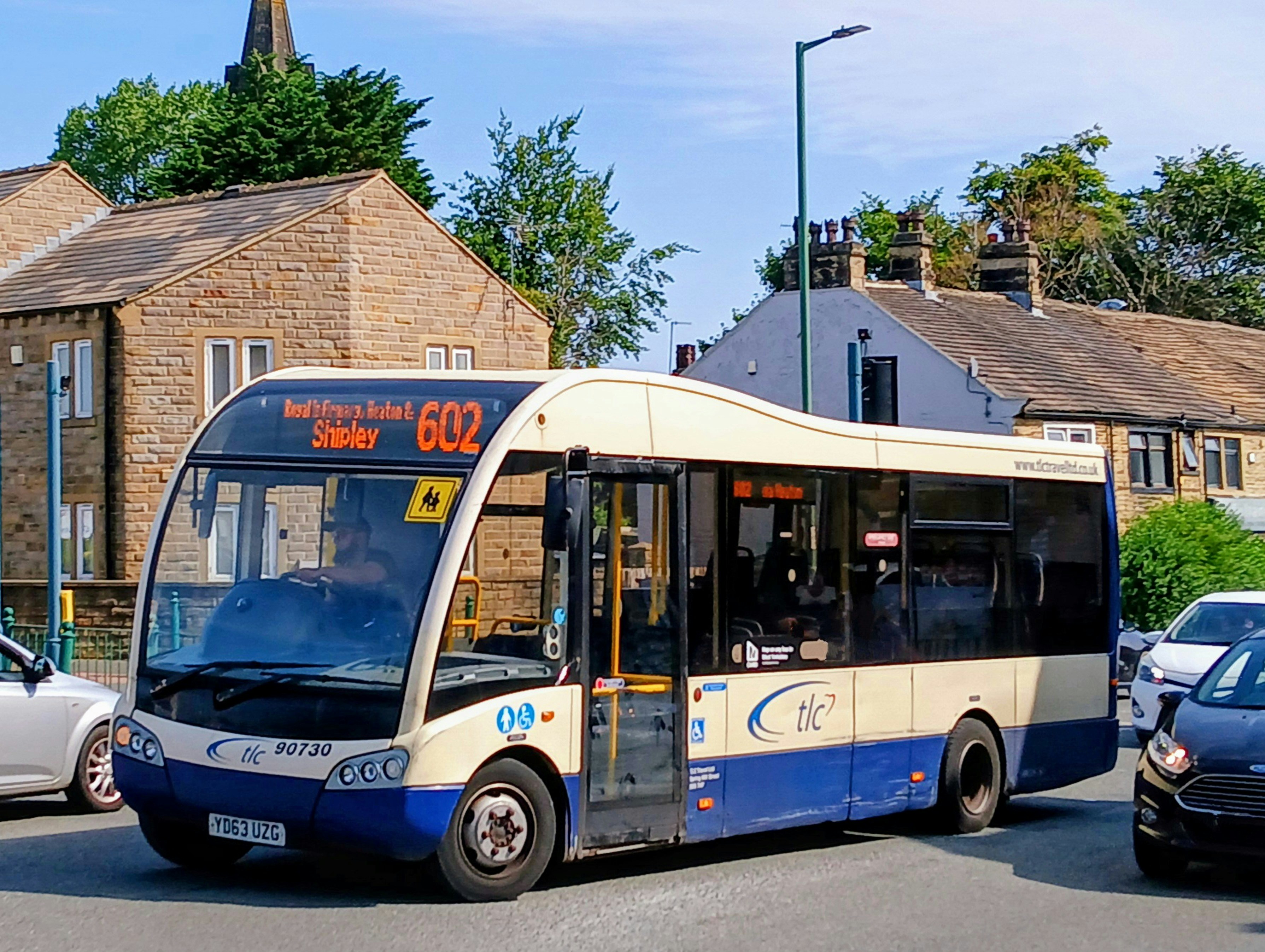 A blue and white bus driving down a street