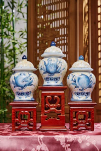Three blue and white vases sitting on top of a table