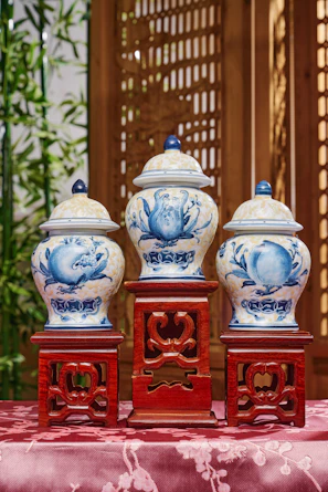 Three blue and white vases sitting on top of a table